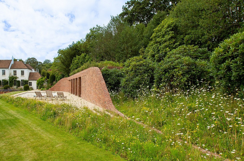 Как настоящий холм: в Англии построили дом с зеленой крышей у бассейна
